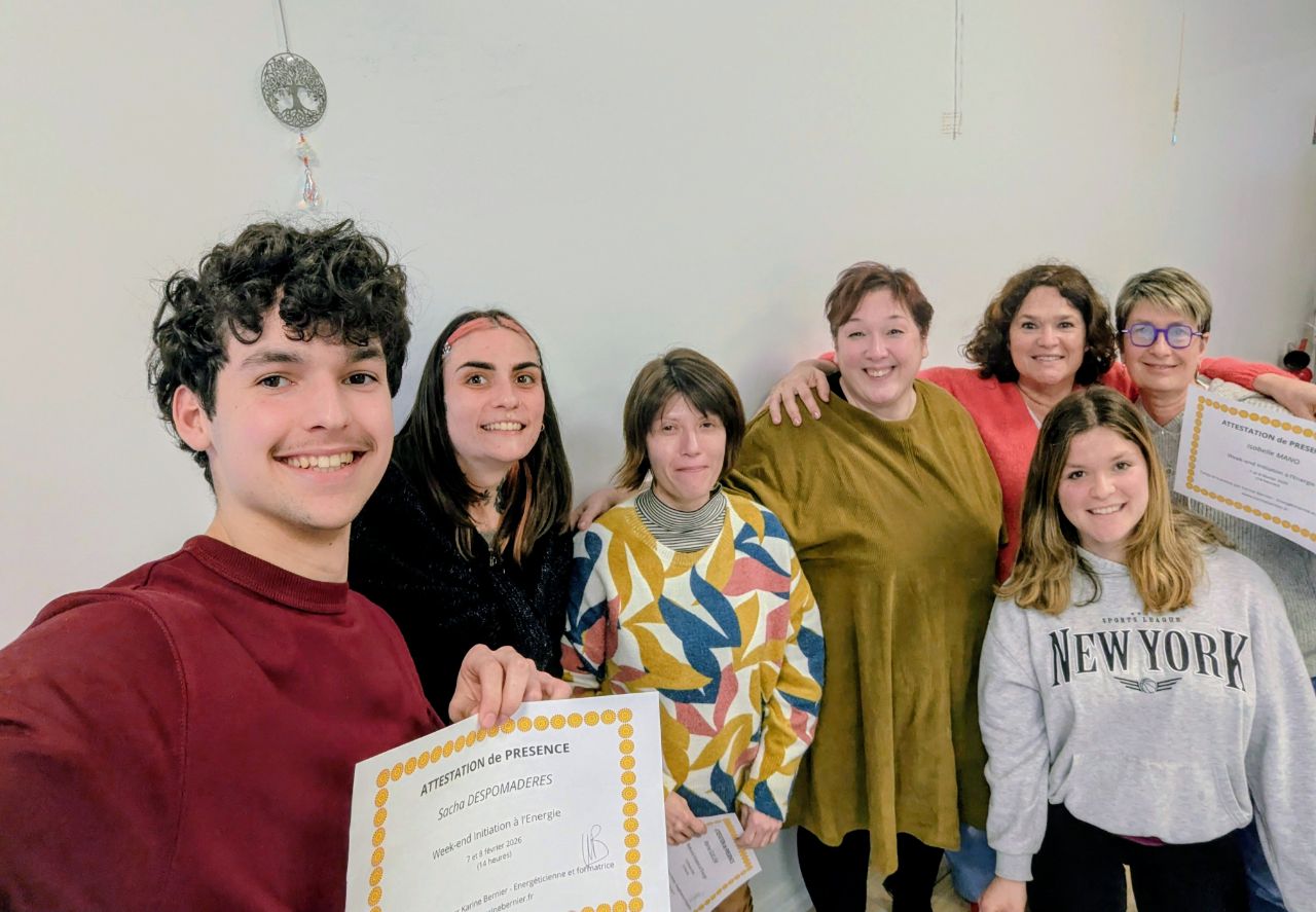 un groupe d'élèves de tous âges pose derrière une attestation de présence à un week-end découverte de l'énergie. Il y a deux adolescents et 5 femmes, tous souriant à la caméra